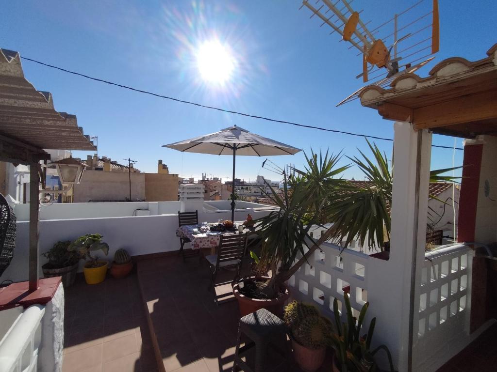 a patio with a table and an umbrella on a roof at Casa Chato Casita San Roque in Alicante