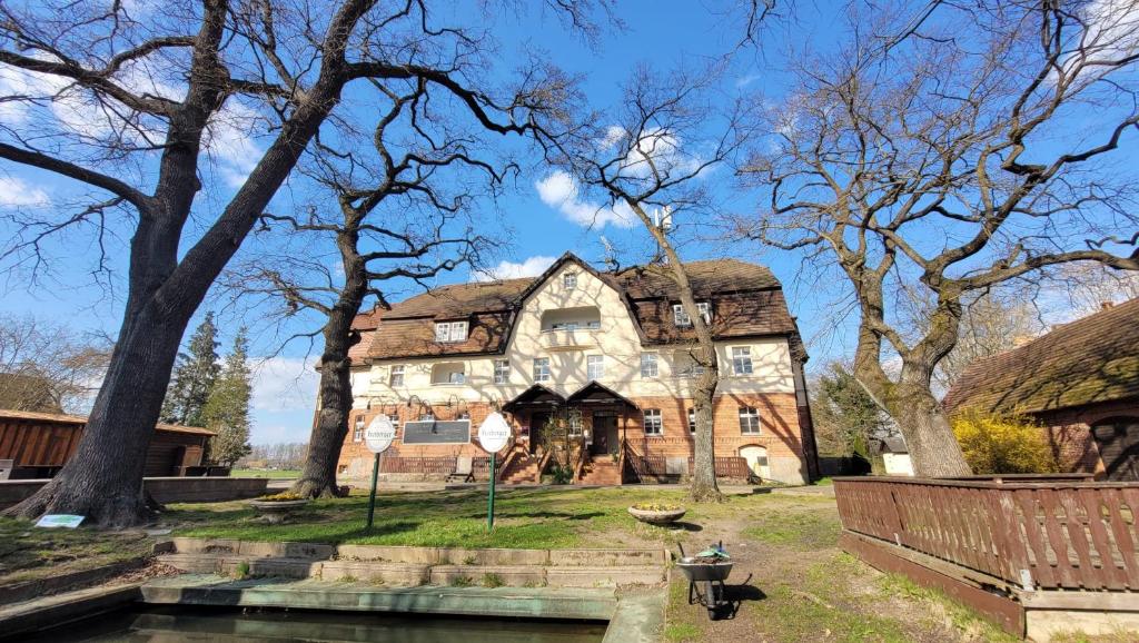 an old house with a thatched roof in a park at Spreewaldhotel Leipe in Leipe