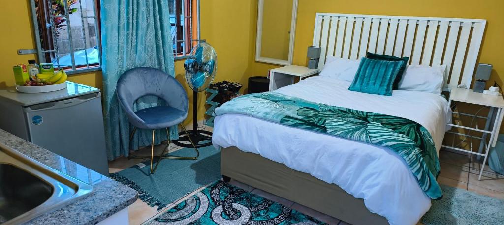 a bedroom with a bed and a chair and a sink at The Homestead Richardsbay in Richards Bay