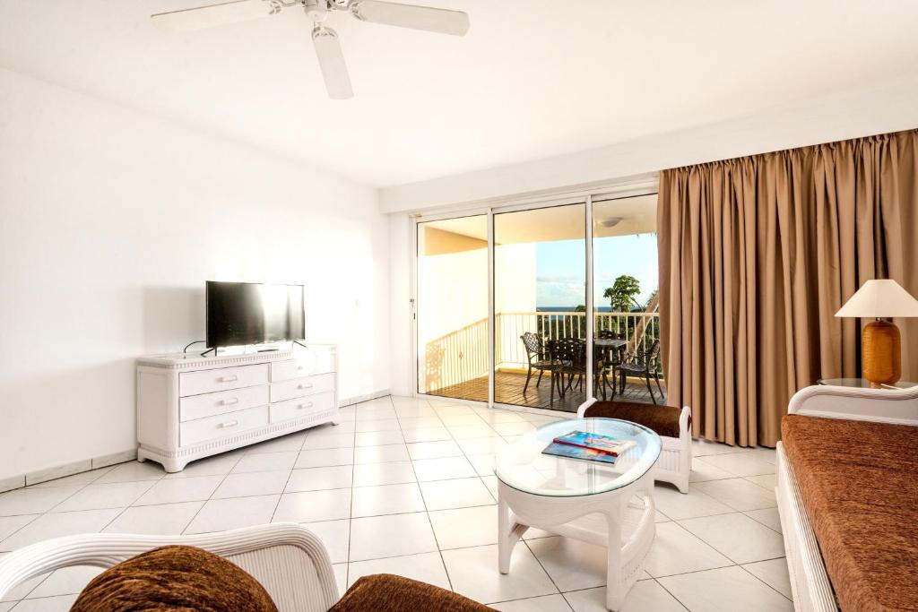 uma sala de estar com um sofá e uma televisão em 2 bedrooms appartement with shared pool furnished balcony and wifi at Lowlands em Lowlands