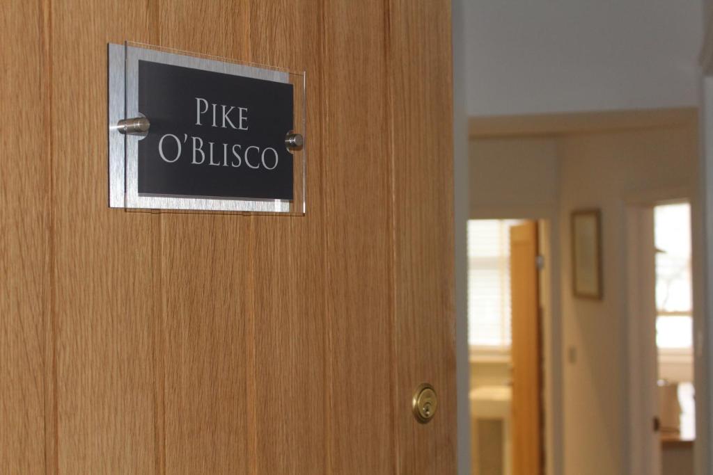 Znak na drzwiach, który przeczyta "rise oxford" w obiekcie Pike O'Blisco w mieście Bowness-on-Windermere