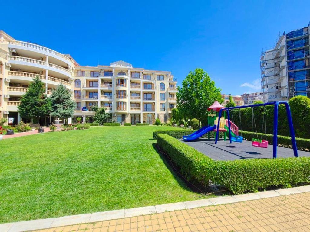 a playground in front of a large building at Royal Bay Аpartment Sylvia in Sveti Vlas