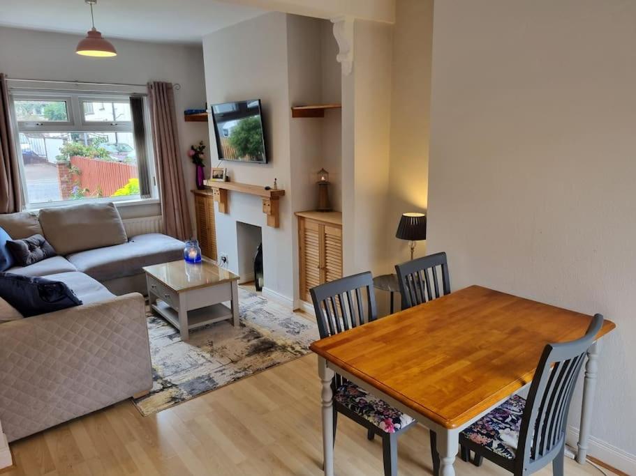 uma sala de estar com uma mesa e um sofá em Darcy's Stopover NITB Approved em Belfast