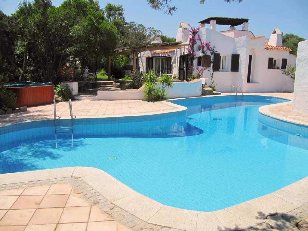 una gran piscina de agua azul frente a una casa en Private Villa ORIONE, en Porto Cervo
