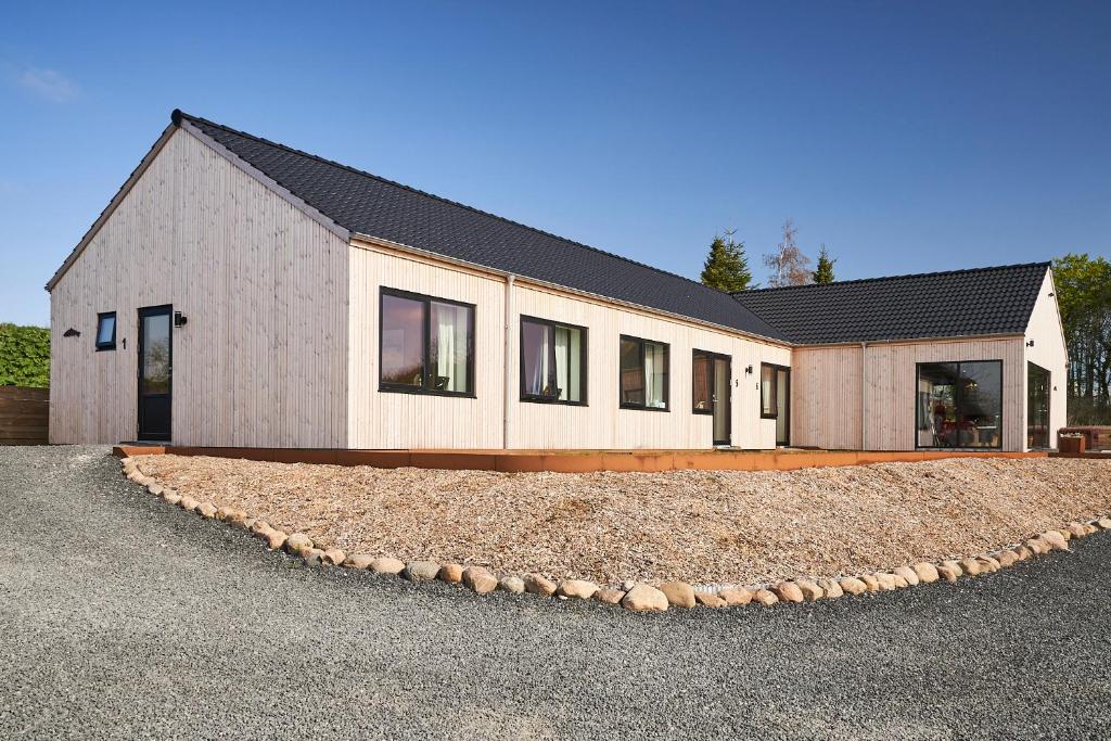 a house with a gravel driveway in front of it at Denmark Outdoor Lodge in Ebberup