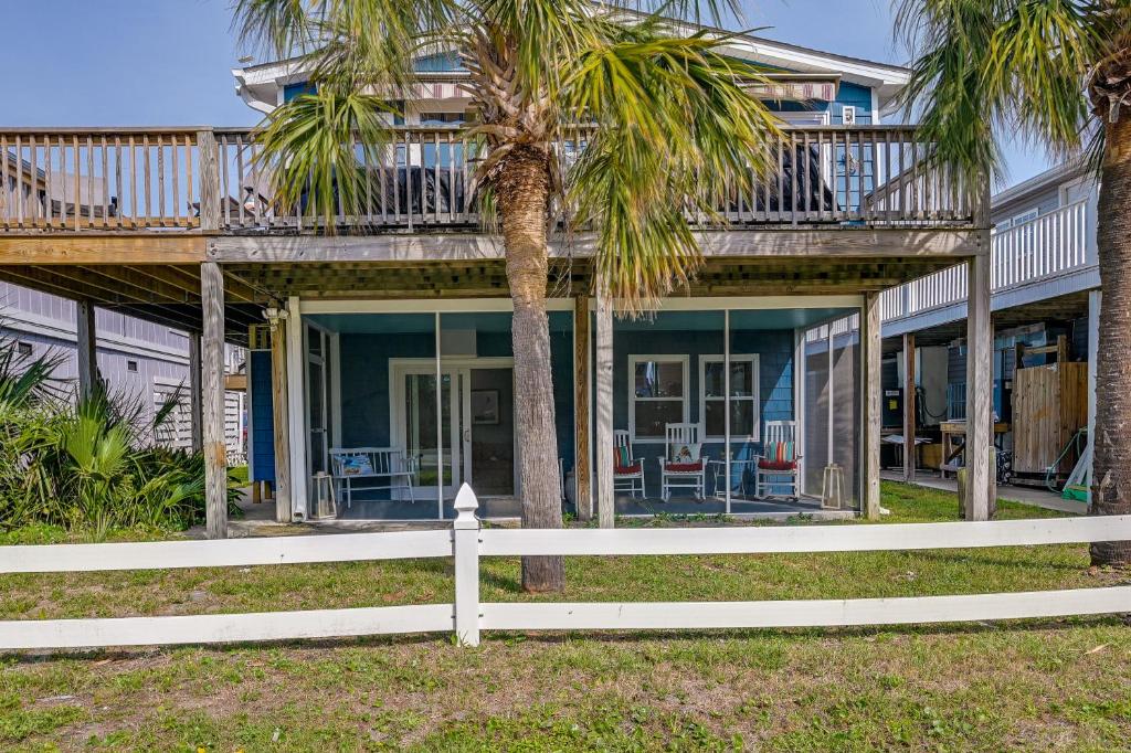 ein Haus mit einer umlaufenden Veranda mit Palmen in der Unterkunft Coastal Surfside Beach House Walk to the Ocean! in Myrtle Beach