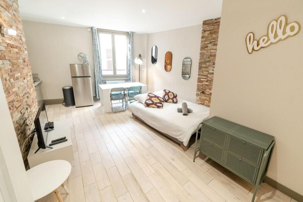 Le NewYorkais - Appartement 4 pers- Oullins-Lyon في أولينز: غرفة معيشة مع سرير وطاولة