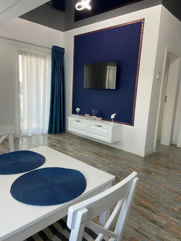 a living room with a white table and a blue wall at Anastasia Residence in Năvodari