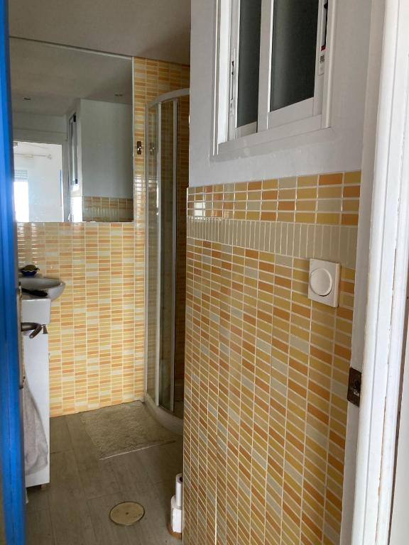 łazienka z żółtymi kafelkami na ścianie i prysznicem w obiekcie Apartamento 1ª linea de mar w mieście Almería
