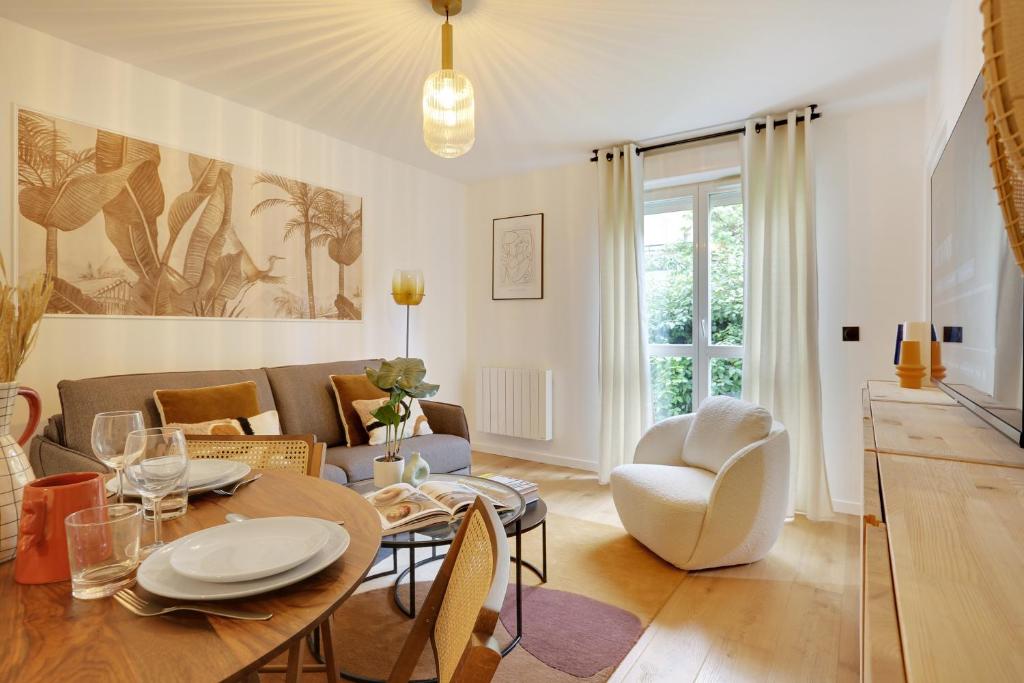 uma sala de estar com uma mesa e cadeiras e um sofá em Amazing apartment 4P/1BR with small garden em Paris
