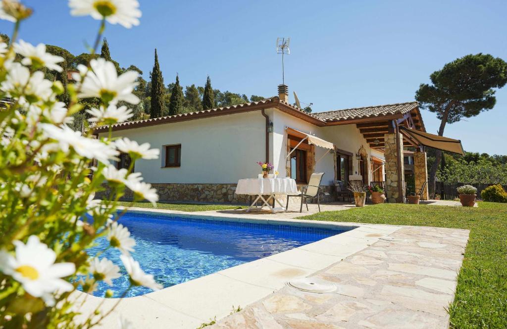 une villa avec une piscine en face d'une maison dans l'établissement Cal Nano Casa Rural, à Vall-llobrega