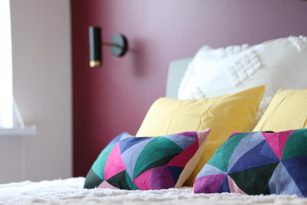 a bed with colorful pillows on it at Spacious Family Friendly apartment, Free Parking in Tallinn