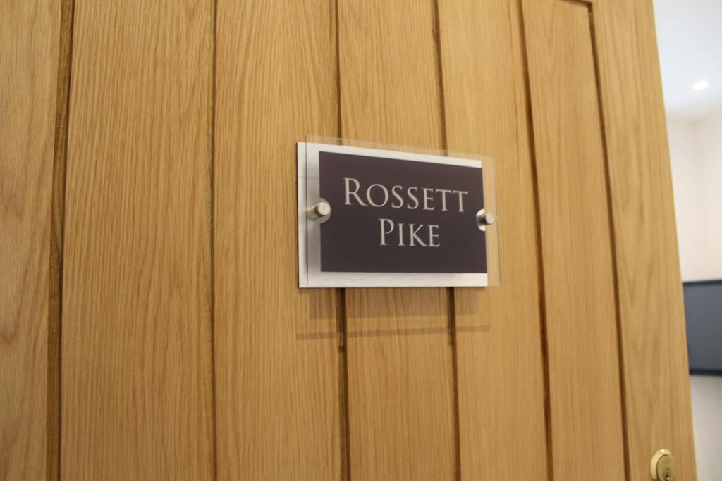 a door with a sign that reads request prize at Rossett Pike in Bowness-on-Windermere