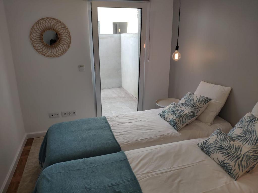 1 dormitorio con cama, sofá y espejo en Colégio 86 en Ponta Delgada