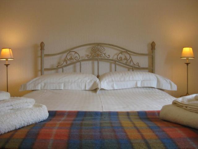 a bedroom with two beds with white pillows at Ardmuir in Turriff