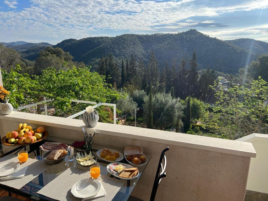 una mesa con platos de comida en la parte superior de un balcón en Olivella Bed&breakfast, en Olivella