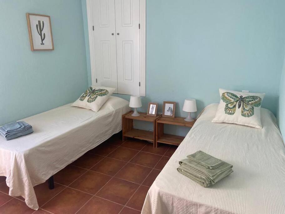 une chambre avec deux lits et une table avec des images dans l'établissement Casa Arlette, à Salobreña