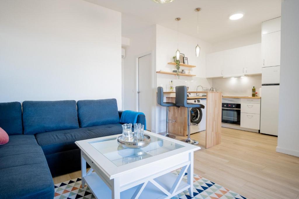 uma sala de estar com um sofá azul e uma mesa em Apartament Glamour La Mata em Torrevieja