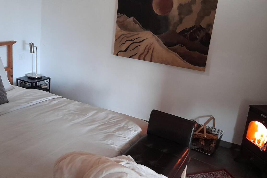 a bedroom with a bed and a laptop on a table at Casa Aguar: Acogedora casa de invitados en el bosque in Barrial