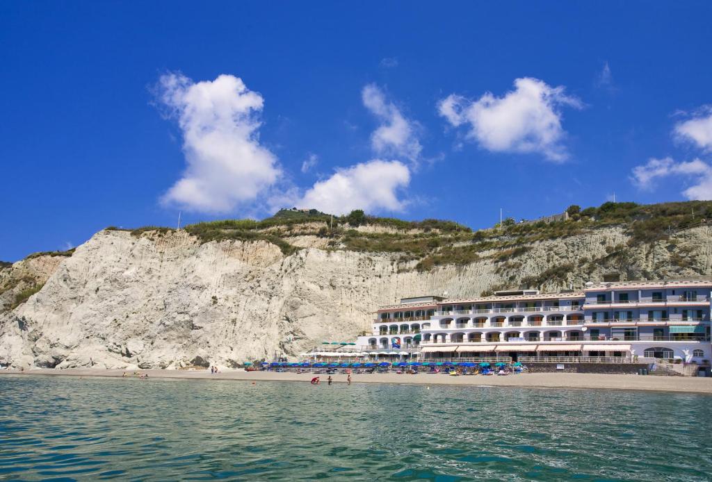 un hotel su una spiaggia vicino a una scogliera di Hotel Vittorio Beach Resort a Ischia