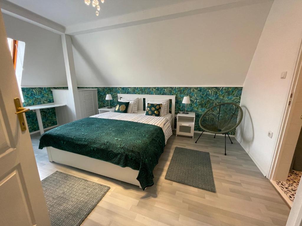 Kétpáva Vendégház في إيغال: غرفة نوم بسرير كبير مع بطانية خضراء