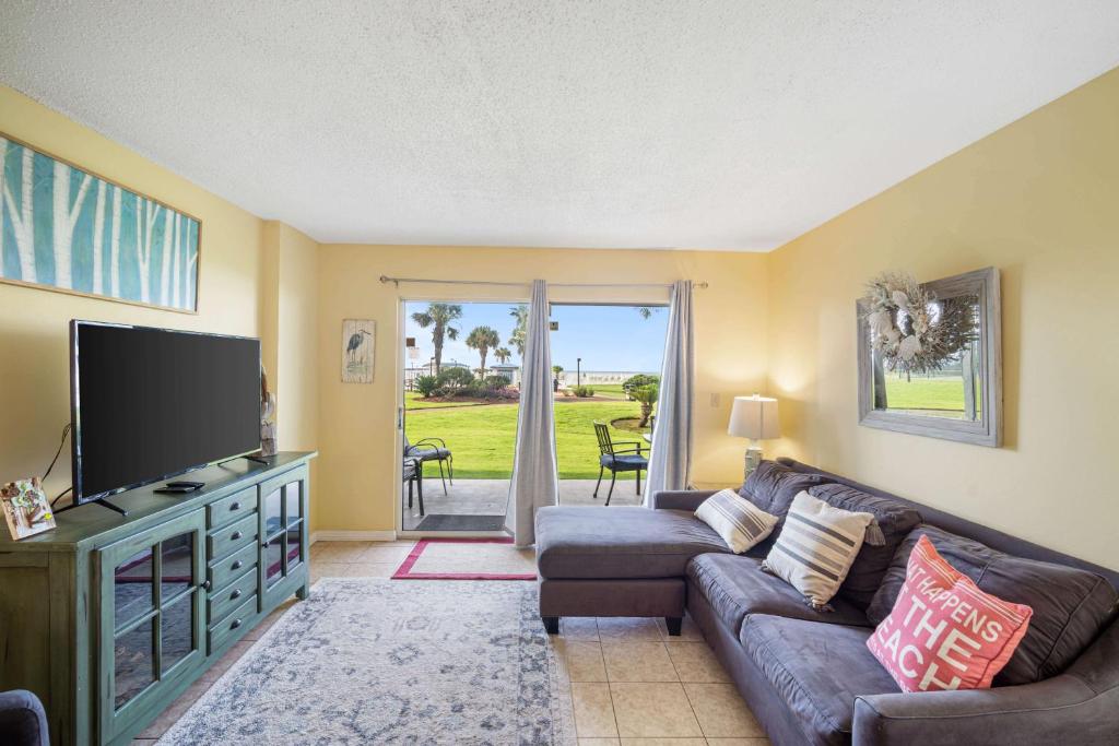 uma sala de estar com um sofá e uma televisão de ecrã plano em Plantation Palms 6110 by ALBVR - Upgraded Ground Floor Beachfront Condo - Lots of Amenities em Gulf Highlands
