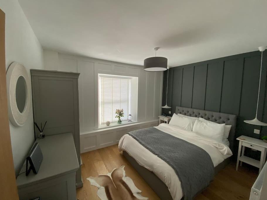 a bedroom with a large bed and a window at Tenby hideaway - by the beaches in Tenby