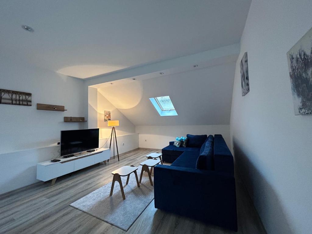 a living room with a blue couch and a tv at Ilidza Blue Nest in Sarajevo