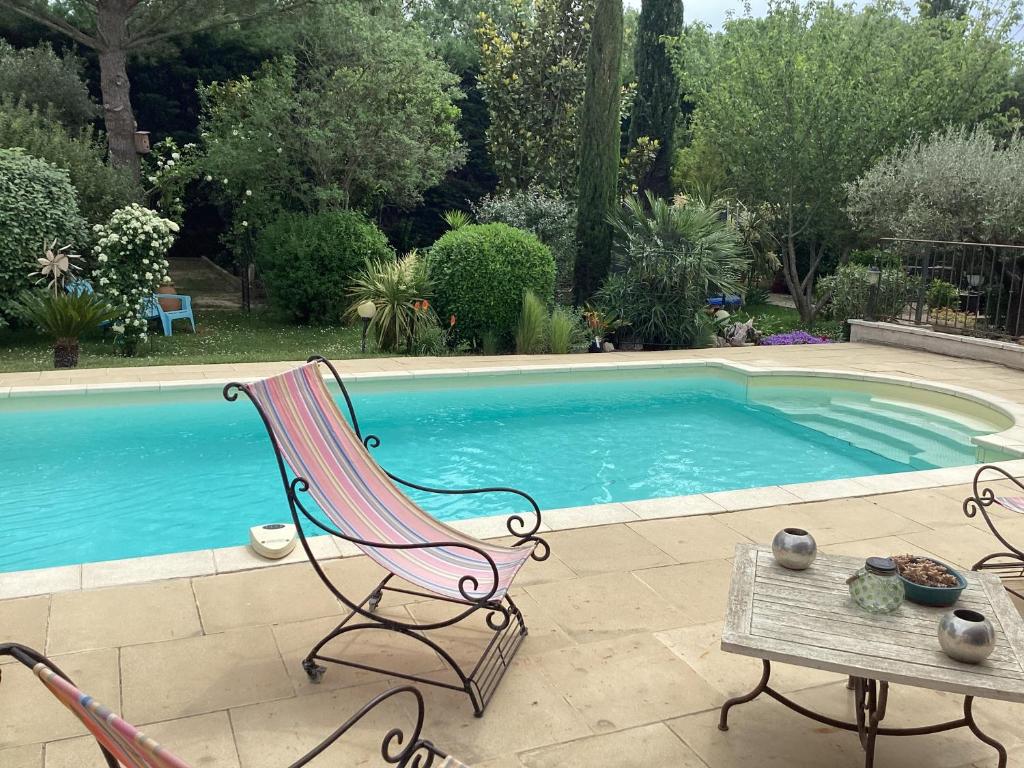 une chaise et une table à côté de la piscine dans l'établissement Studio en Provence avec piscine, à Graveson