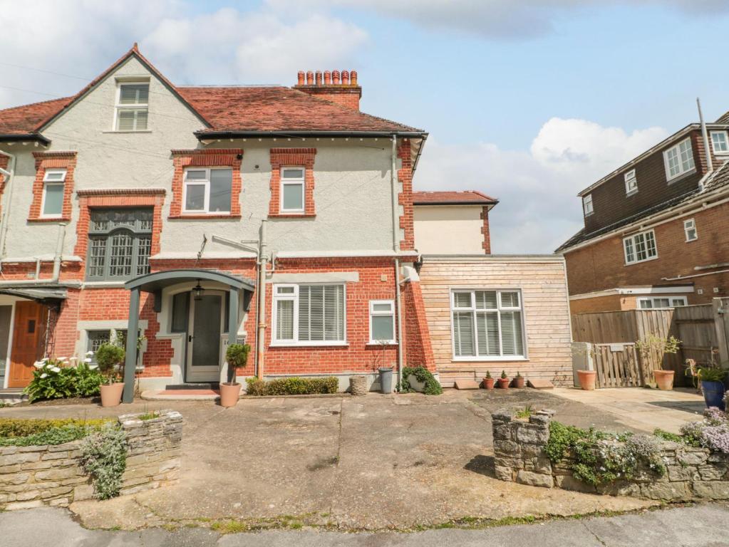 a brick house with a driveway in front of it at The Anchorage in Bournemouth