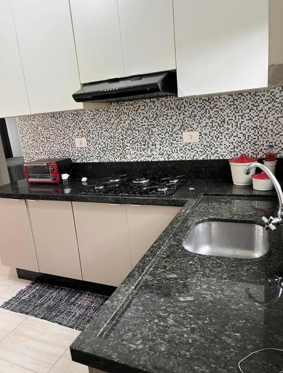 a kitchen with a sink and a counter top at Casa região central Guaratuba in Guaratuba