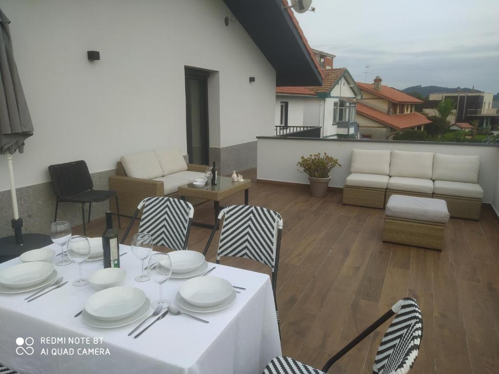 una mesa blanca y sillas en un patio en la azotea en Aldaiondo, en Berango