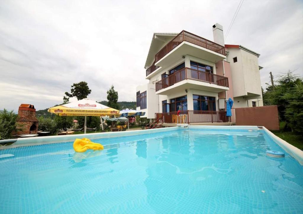 a large swimming pool in front of a house at Gonio Hills • Batumi in Batumi