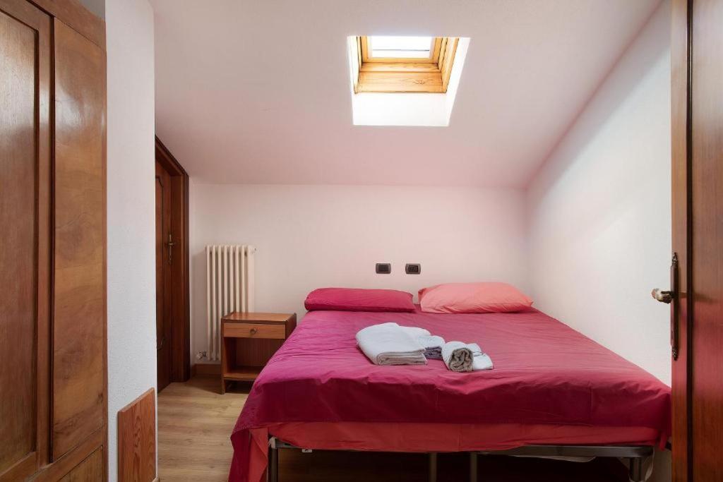 - une chambre avec un lit et une couverture rouge dans l'établissement Atirano, à Tirano