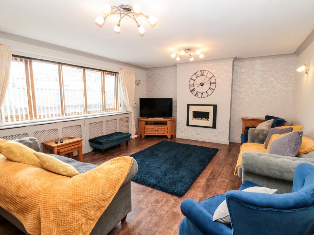 uma sala de estar com dois sofás e uma televisão em 5 Westwood Road em Scarborough
