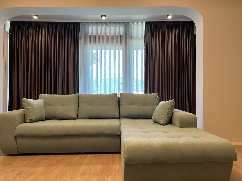 a couch sitting in front of a large window at Apart Central in Orşova