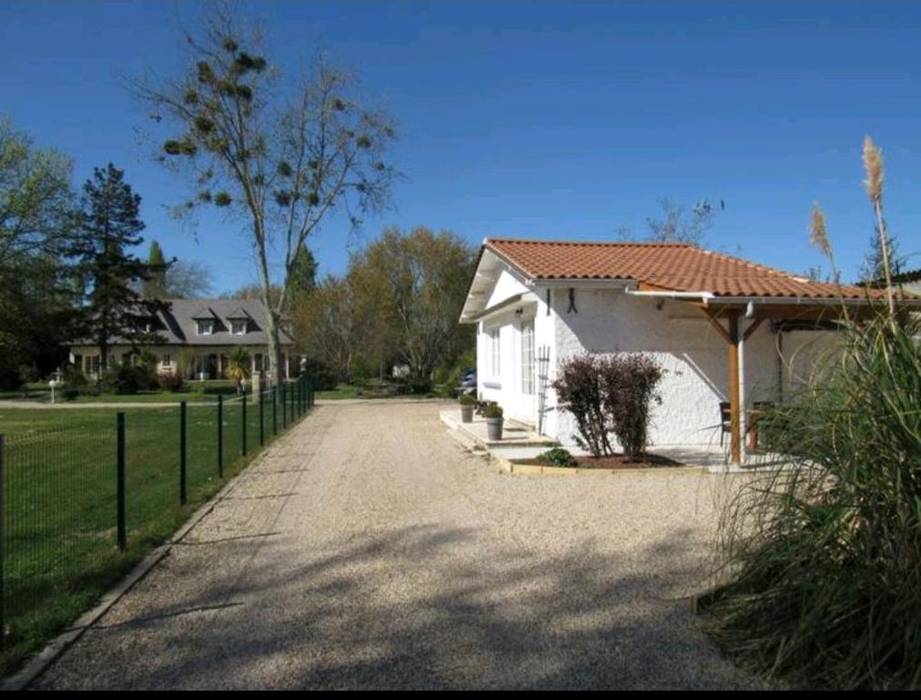 een huis met een hek naast een oprit bij Gîte de la Perigourdine in Pineuilh