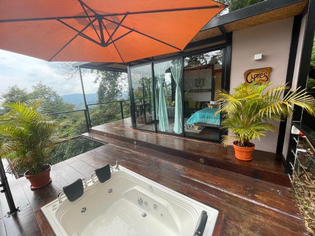 a jacuzzi tub on a deck with an umbrella at Balú Glamping in San Francisco