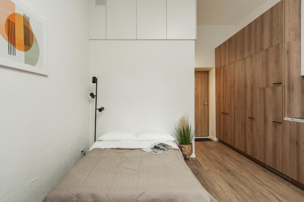 a bedroom with a bed and a wooden door at Air Apartment 104 in Vilnius