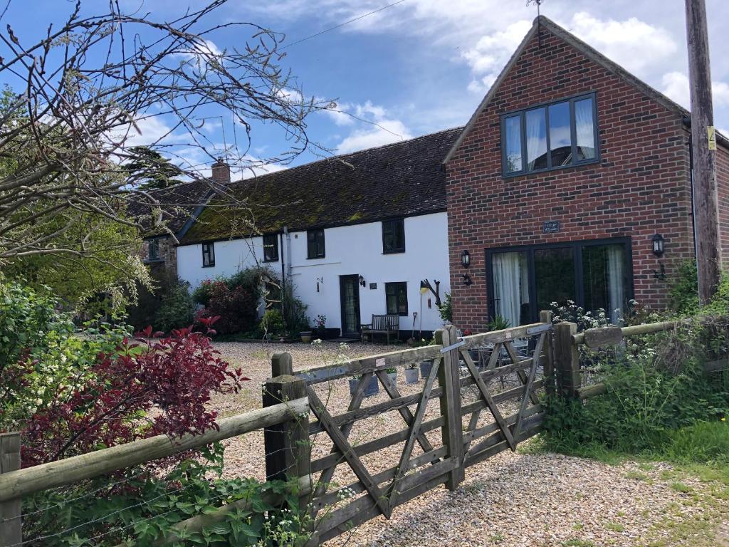 a house with a fence in front of it at Little Stables Cottage in Blandford Forum