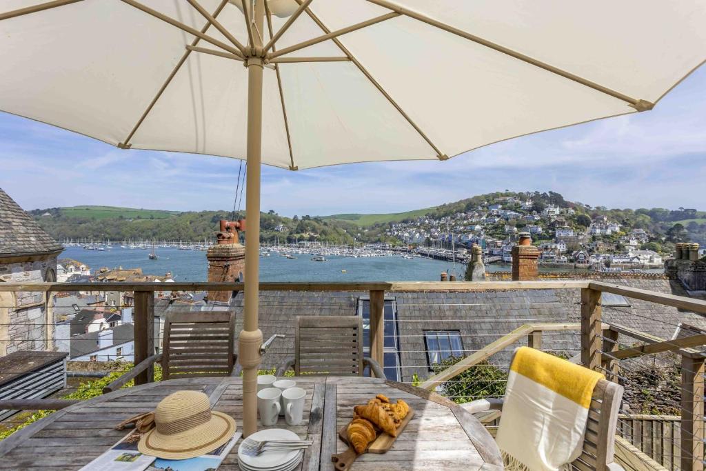 a table with an umbrella on a balcony at The Admiralty Wash House in Dartmouth