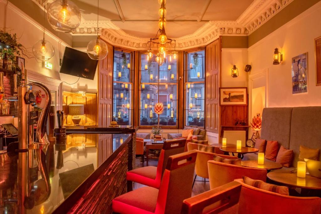 restauracja ze stołami i krzesłami oraz dużym oknem w obiekcie No32 Hotel w Edynburgu