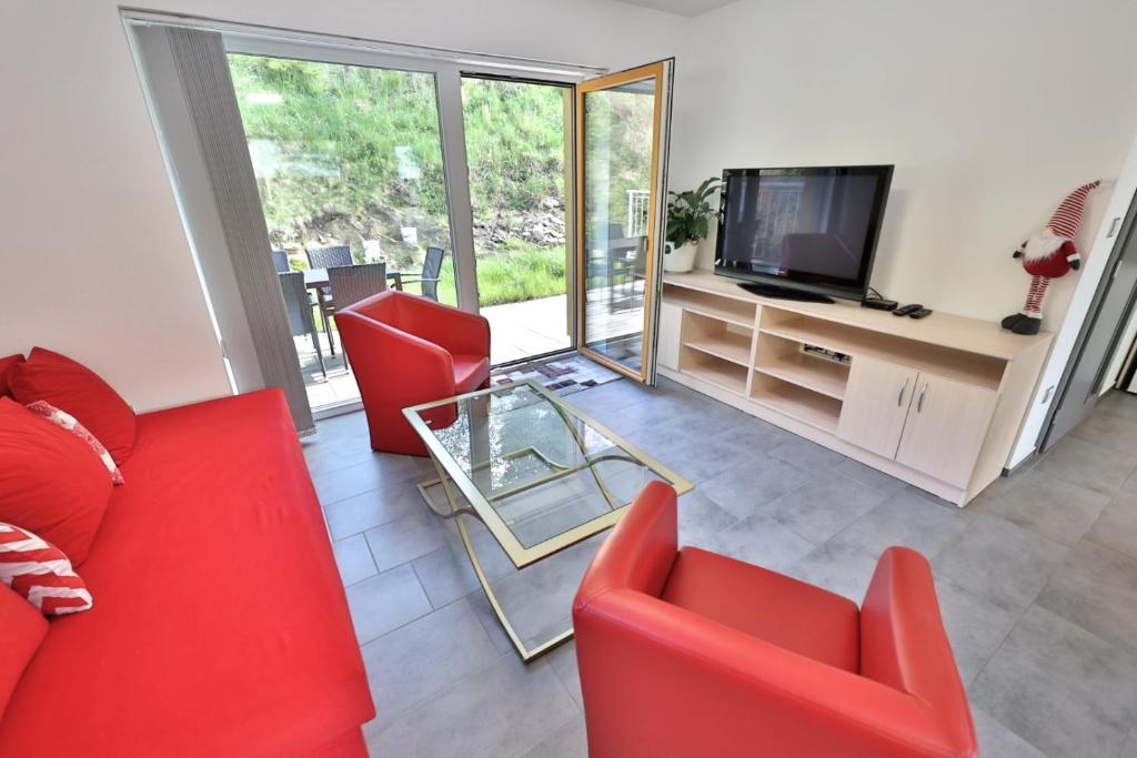 sala de estar con sillas rojas y TV en Apartmány Vír, en Vír