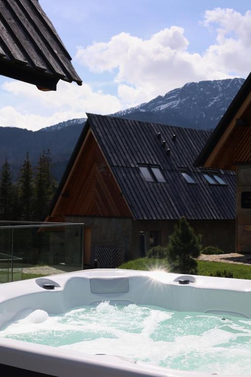 bañera de hidromasaje grande frente a un edificio en Górski Domek Zakopane en Kościelisko