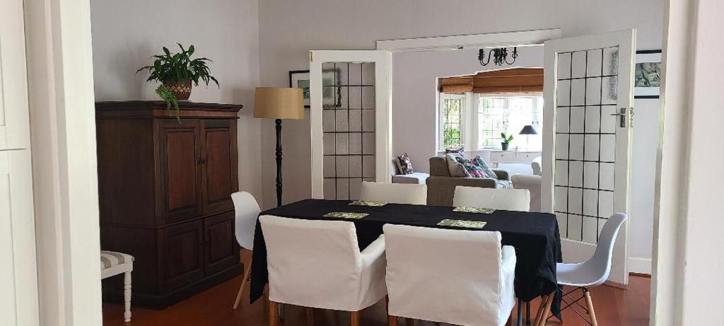 a dining room with a table and white chairs at Innes Road Durban Accommodation 2 Bedroom Private Unit A in Durban