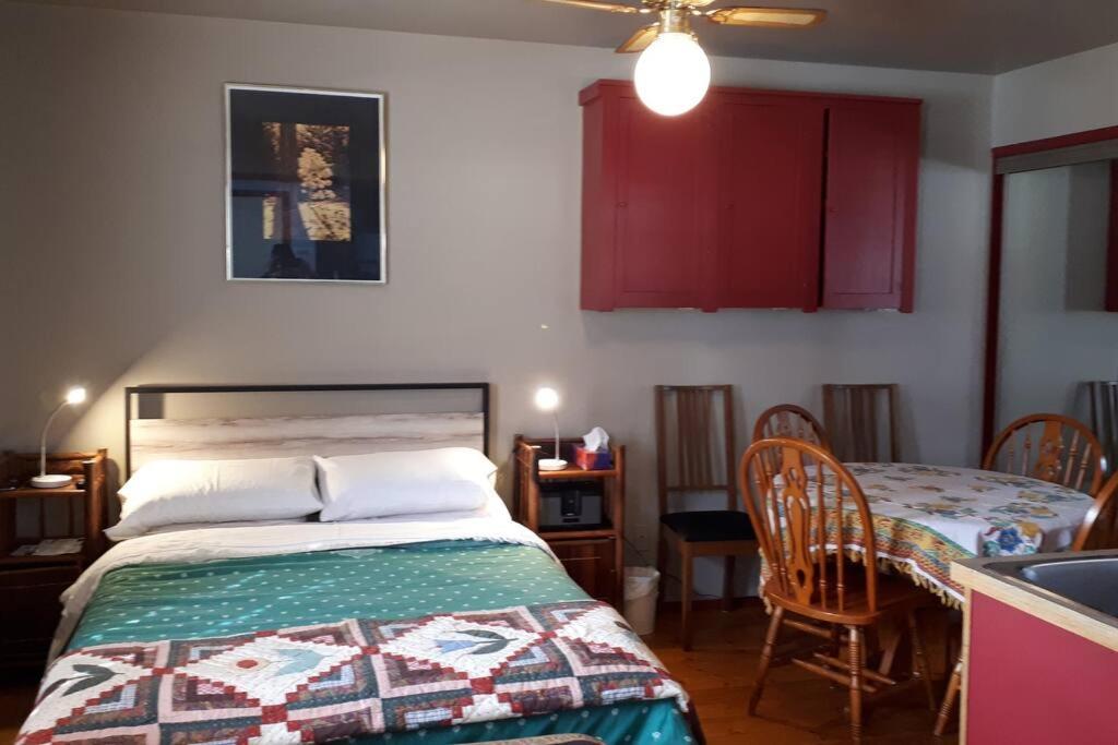 a bedroom with a bed and a table with chairs at Luisa's guest suite in Keremeos