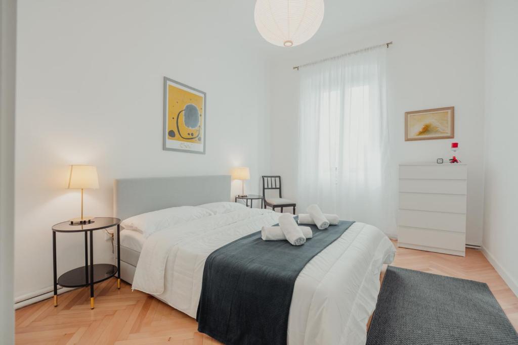 een witte slaapkamer met een bed met twee handdoeken erop bij Piccardi in Trieste