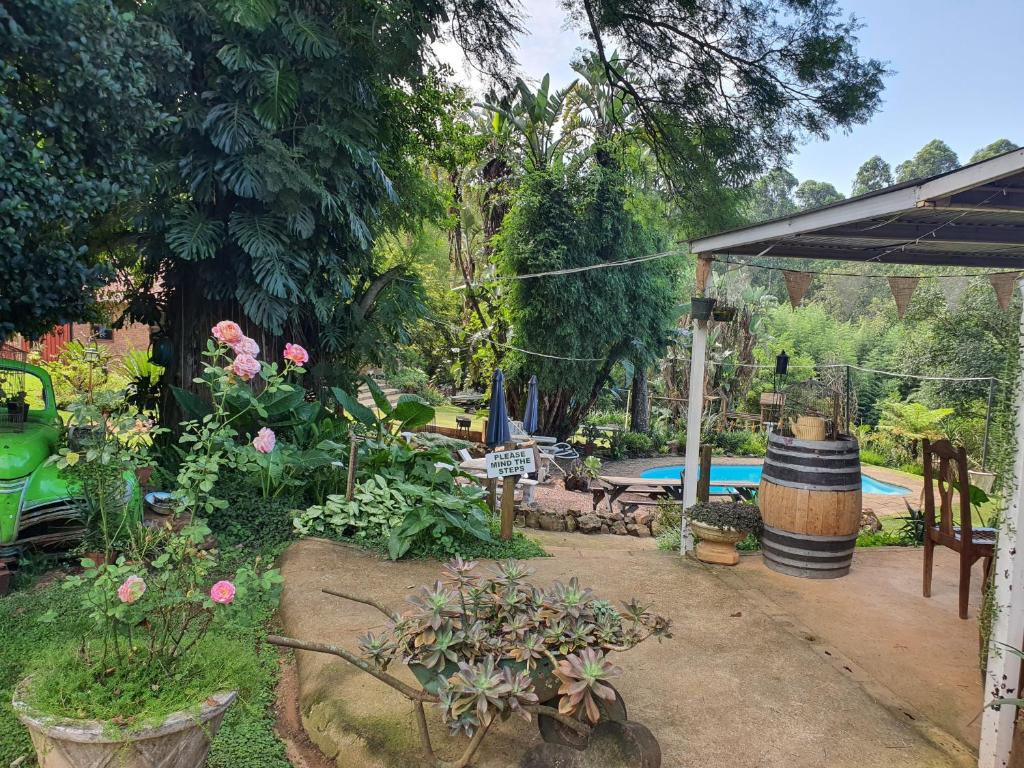 a garden with a swimming pool and some flowers at ROCKABILLY RANCH Self-Catering Guest Units in Pietermaritzburg