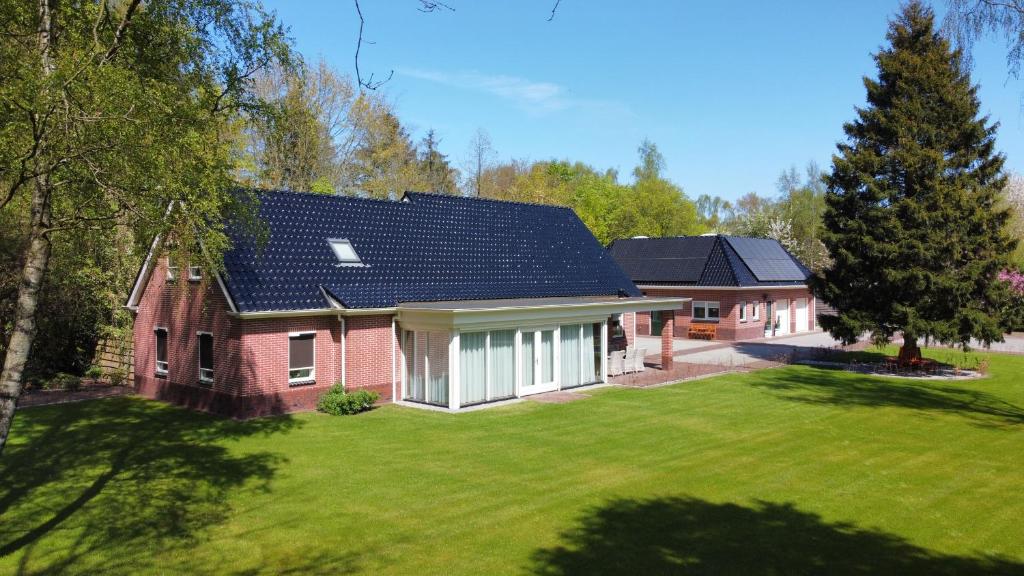 una casa de ladrillo rojo con techo solar en B&B Bosstee, en Vledderveen