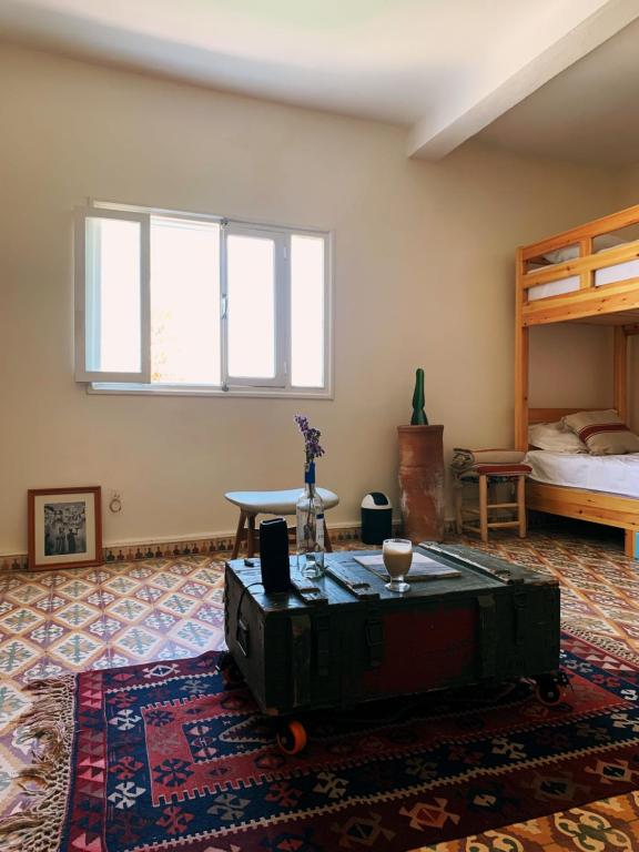 Una habitación con una cama y una mesa en una habitación en El MOJA SURFHOUSE, en Sidi Ifni